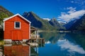 Beautiful red fishing house on fjord. Beautiful nature with blue sky, reflection in water and fishing house. Norway Royalty Free Stock Photo