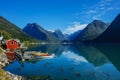 Beautiful red fishing house on fjord. Beautiful nature with blue sky, reflection in water and fishing house. Norway Royalty Free Stock Photo