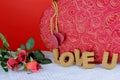 A beautiful red and gold candy box on a white table with a red background. Cork letters spell the words love u for Valentine`s Da Royalty Free Stock Photo