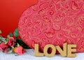 A beautiful red and gold candy box on a white table with a red background with red roses. Cork letters spell the word love for Royalty Free Stock Photo