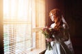 Beautiful red hair bride near window Royalty Free Stock Photo