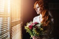 Beautiful red hair bride near window Royalty Free Stock Photo