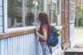 Beautiful red hair woman with backpack looking in the window of scary old house Royalty Free Stock Photo