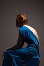 Beautiful red hair woman in blue sexy dress with open back Royalty Free Stock Photo