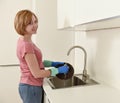 Beautiful red hair woman smiling happy and positive washing the dishes at kitchen sink Royalty Free Stock Photo