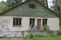 Beautiful red hair woman tourist with backpack exploring abandoned summer camp