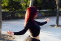 Beautiful red haired ballerina in black leotard gracefully dancing at a park Royalty Free Stock Photo