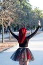 Beautiful red haired ballerina with orange pointe shoes gracefully dancing at a park Royalty Free Stock Photo