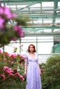 Red-haired girl in arranger where azalea blooms in a colorful flying dress Royalty Free Stock Photo