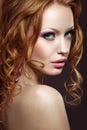 Beautiful red-haired girl with bright makeup and curls. Royalty Free Stock Photo