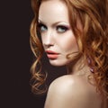 Beautiful red-haired girl with bright makeup and curls. Royalty Free Stock Photo