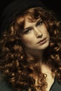 Beautiful red-haired girl with curls, black hat Royalty Free Stock Photo