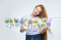 Beautiful red-haired girl hangs euro banknotes on a rope
