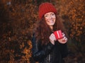 Beautiful red-haired girl in hat with a red cup. Royalty Free Stock Photo