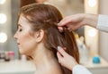 Beautiful, red-haired girl with long hair, hairdresser weaves a French braid, Royalty Free Stock Photo