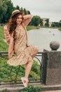 beautiful red-haired girl.picture against the background of the river, water, lake in the park, summer.holds a hat and smiles Royalty Free Stock Photo