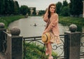 beautiful red-haired girl.picture against the background of the river, water, lake in the park, summer..sits on a fence, in the ha Royalty Free Stock Photo