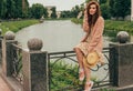 beautiful red-haired girl.picture against the background of the river, water, lake in the park, summer..sits on a fence, in the ha Royalty Free Stock Photo