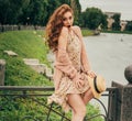 beautiful red-haired girl.picture against the background of the river, water, lake in the park, summer.the wind raises the skirt o