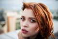 Beautiful red-haired girl with plump lips. Walking around the city. A natural beauty. Roof.Ginger