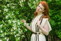 Beautiful red-haired girl walks in apple orchard Royalty Free Stock Photo