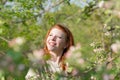 Beautiful red-haired girl walks in apple orchard Royalty Free Stock Photo