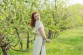 Beautiful red-haired girl walks in apple orchard Royalty Free Stock Photo