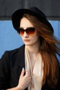 Beautiful red-haired model in sunglasses and black hat Royalty Free Stock Photo