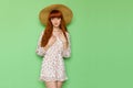 Beautiful red haired teen girl is posing in summer dress and straw hat Royalty Free Stock Photo