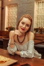 Face portrait of red-haired woman sitting at the bar