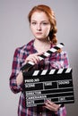 Beautiful red-haired woman holding a movie clapper Royalty Free Stock Photo
