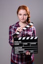 Beautiful red-haired woman holding a movie clapper Royalty Free Stock Photo