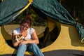 Beautiful red-haired woman is resting in nature with her pet. A girl sits in a tourist tent and hugs a Jack Russell Royalty Free Stock Photo