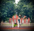 Beautiful red house with green trees and lawn in New England, Massachusetts on a rainy day Royalty Free Stock Photo