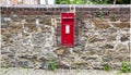 Beautiful red mailbox built into a stone wall