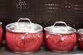 Beautiful red new pans stand on a shelf in a store Royalty Free Stock Photo