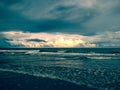 Beautiful red-orange light in the clouds over the ocean. Storm and rain at sea. Dark sky with rain clouds over the ocean Royalty Free Stock Photo