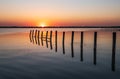 Beautiful red and orange sunset over the sea. The sun goes down over the sea. An old sea pier in orange sunset light Royalty Free Stock Photo