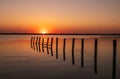 Beautiful red and orange sunset over the sea. The sun goes down over the sea. An old sea pier in orange sunset light Royalty Free Stock Photo