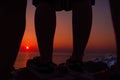 Beautiful red orange Sunset view framed by tourist legs, Oia Santorini, Greece Royalty Free Stock Photo