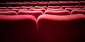 The beautiful red seats are lined up inside the cinema