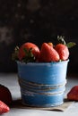 Beautiful red strawberry in blue pot. Strawberries on black dark background Royalty Free Stock Photo