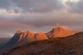 Beautiful red sunlight from the rising sun illuminating the Langdale Pikes mountain range in the English Lake District. Royalty Free Stock Photo