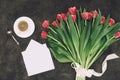 Beautiful red tulips, cup of coffee and blank envelope with greeting card Royalty Free Stock Photo