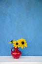 Beautiful red vase with yellow flowers Royalty Free Stock Photo