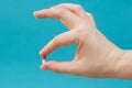 A beautiful red and white pill clamped in his fingers. Shows a pill. A pill for all diseases, vitamin, food supplement, Horizontal Royalty Free Stock Photo