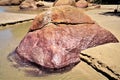 Beautiful reddish colored stone on the edge of the freshwater stream on the beach