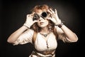 Beautiful redhair steampunk girl looking over her goggles aside Royalty Free Stock Photo