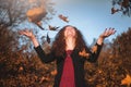 Beautiful redhaired girl with a falling leaves.