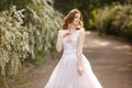 Beautiful redhead Bride in fantastic wedding dress in blooming garden. Royalty Free Stock Photo